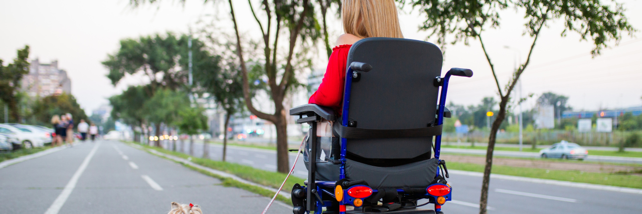 Being Independent as a Person With Cerebral Palsy Woman in power wheelchair walking her dog.