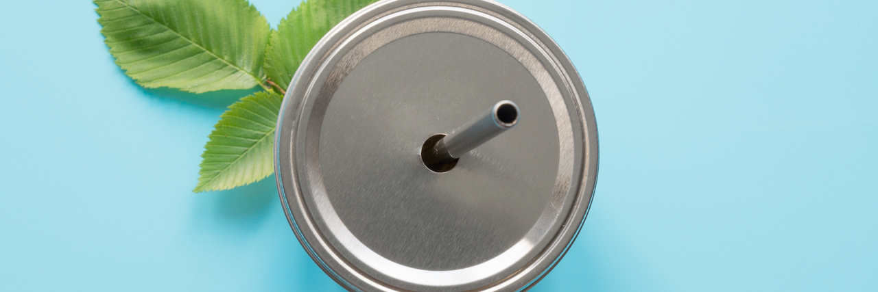 Top view of a reusable jar with a metal lid and a straw for summer drinks. Reusable application. Individual use. Save the planet. Concept zero waste. (Top view of a reusable jar with a metal lid and a straw for summer drinks. Reusable application. Ind