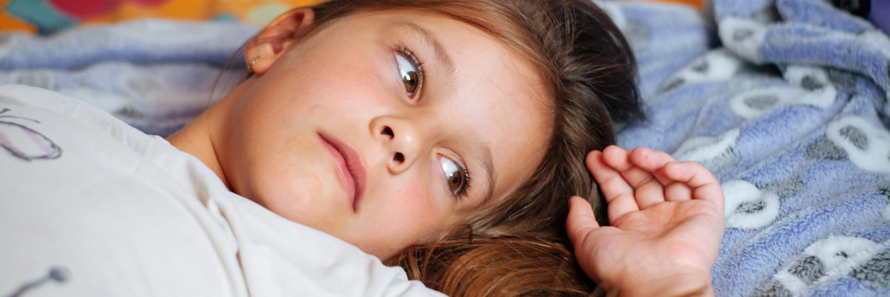 The Invisible Wounds of Childhood Bullying Sad little girl lying in bed in the bedclothes