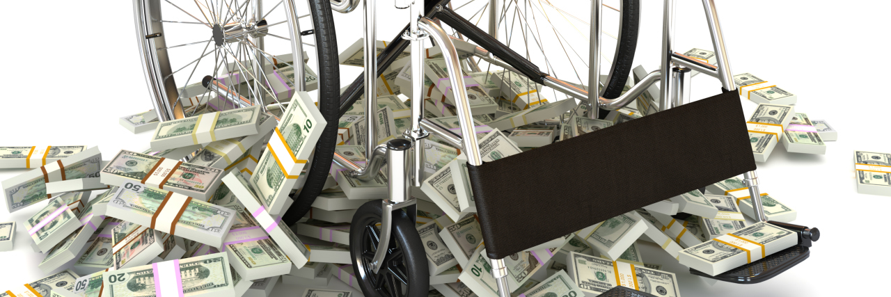 an image of a wheelchair with stacks of money piled around it
