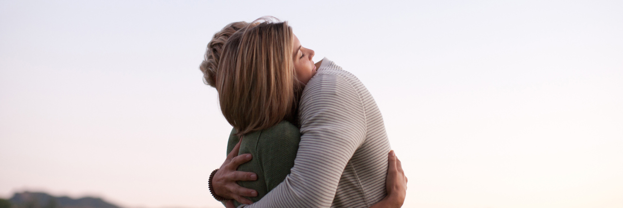 3 Things to Stop Saying to a Caregiver of a Veteran Couple hugging outdoors