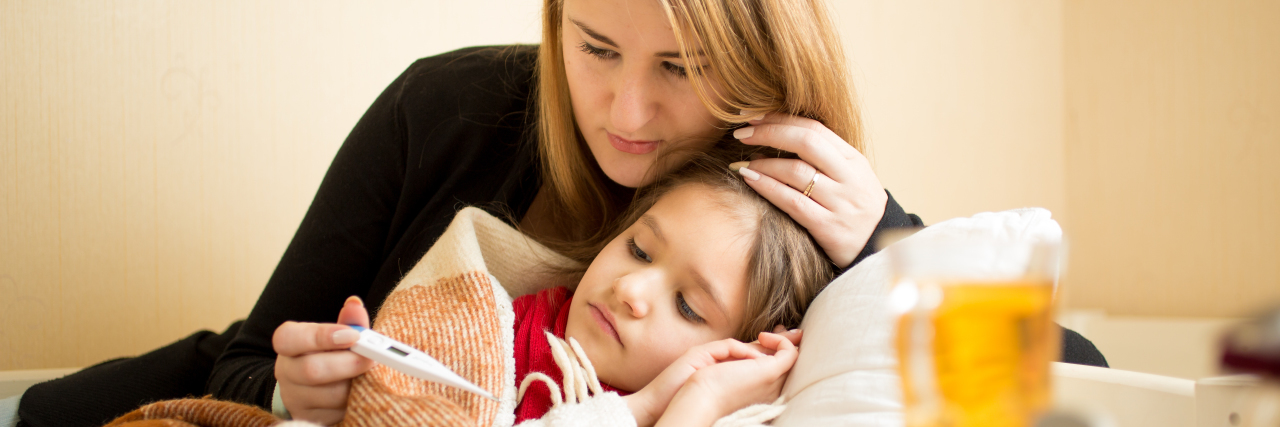 Parenting a Medically Fragile Child: Preparing for Illness mother checking daughter's temperature in bed