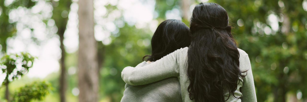 When You're Depressed Being in Someone Else's Presence is Powerful two friends hugging at the park