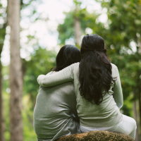 two friends hugging at the park