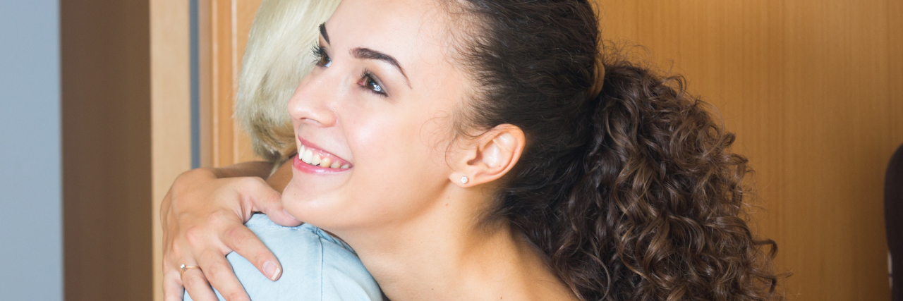 When My Mother-in-Law Said, 'I Hope You Feel Better Soon' an older woman is hugging a younger woman with a young man smiling next to them