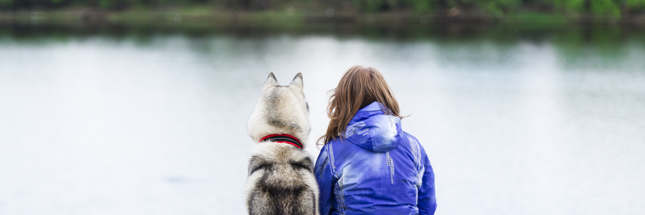 Don't Pity Me Because of My Disability Dog and woman sit on the river bank.