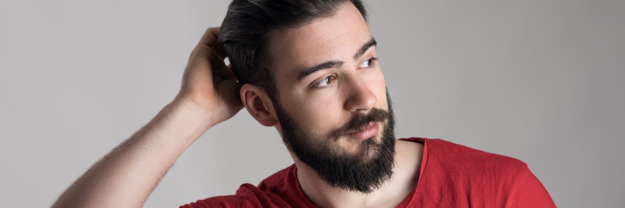 How My OCD Makes It Impossible to Say What I Feel A man in a red shirt scratching his head