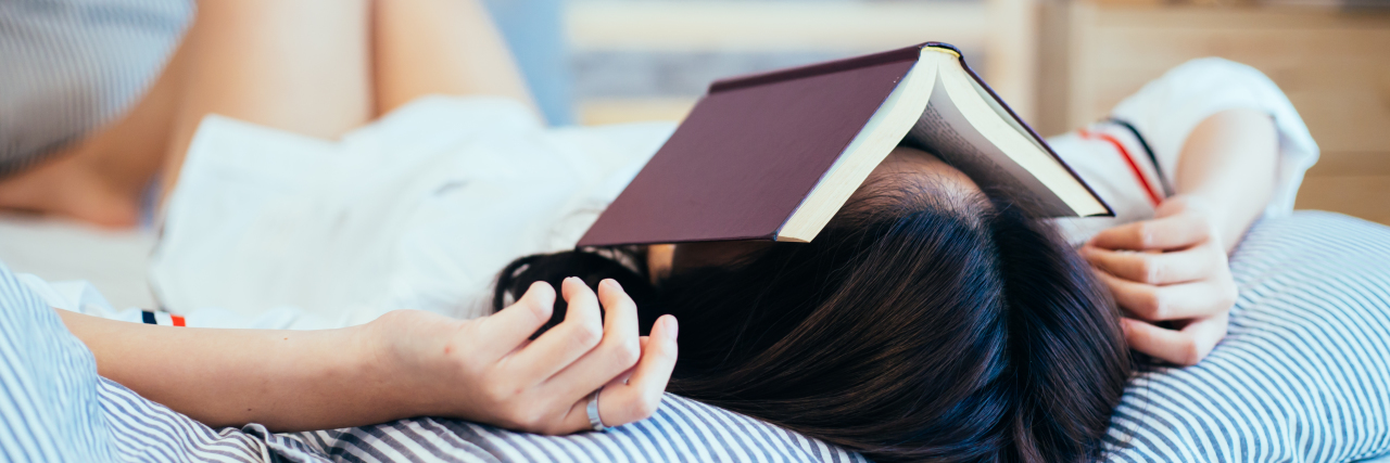 What Students Wish Their Teachers Knew About Mental Illness a woman lying on a bed with a book on top of her face