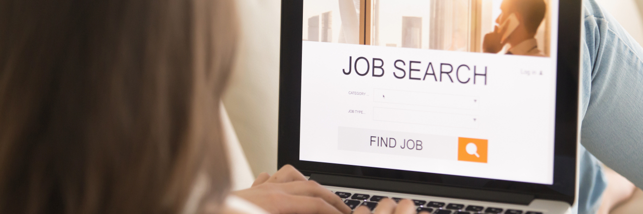 Woman lying on sofa with laptop searching for a job.