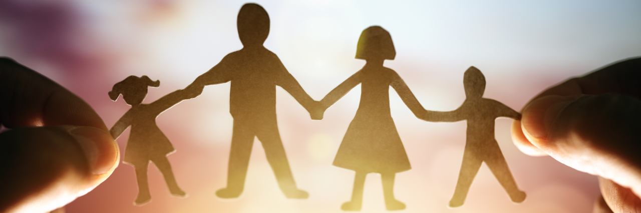 True Inclusion for My Autistic Family Paper chain family held up to sunset.