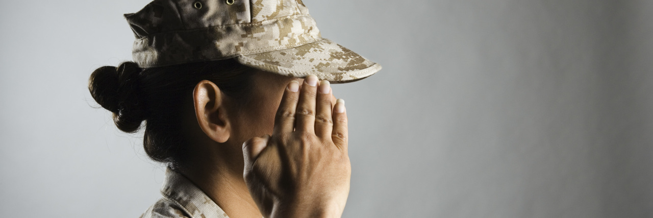 A woman U.S. marine is saluting.