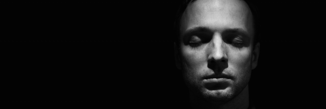 Why People Blame Mass Shootings on Mental Illness A black and white portrait of a man closing his eyes