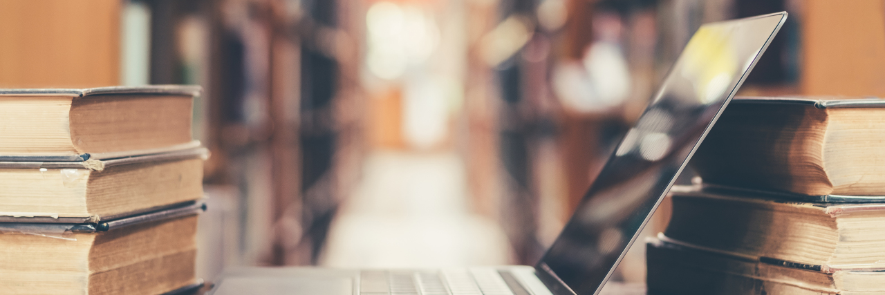 Tips for Going to College With a Physical Disability Books and laptop in university library.