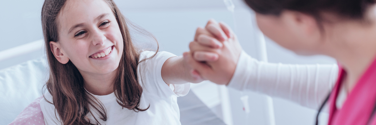 The Unexpected Superpowers I Have as a Chronically Ill Nurse A smiling girl giving a high five to her nurse.