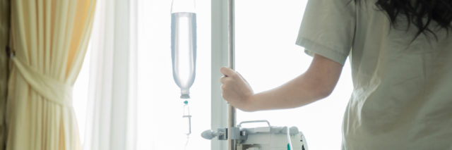 patient holding onto infusion pole