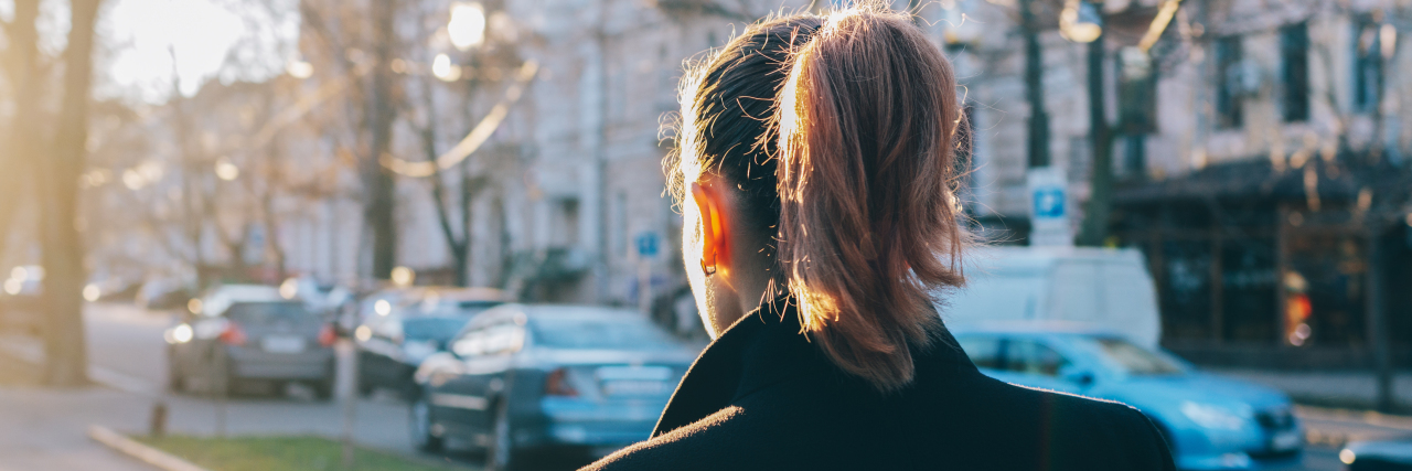 After Being Diagnosed With Mental Illness, I Raised Myself Again A woman with brown hair is walking through the city