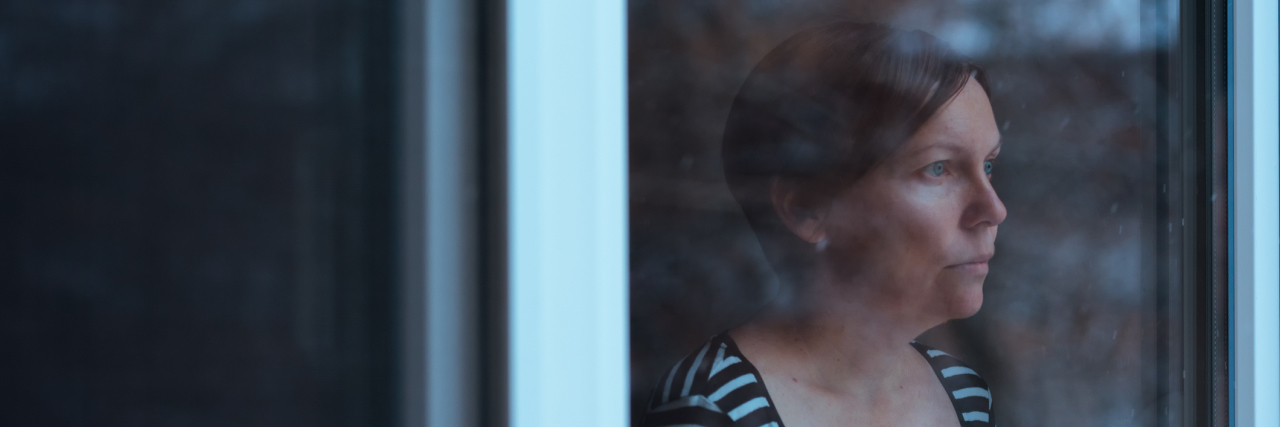 What Helped Me Battle Isolation as a Parent of a Medically Fragile Kid Woman standing by the window and looking outside