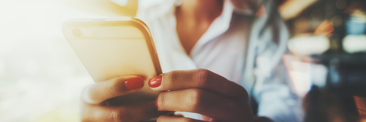 Things I Have Learned as a Samaritans Suicide Hotline Volunteer Closeup wide-angle view of the hands with a red nails of girl sitting next to a window on a sunny day and texting a message