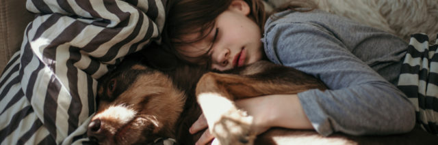Girl hugging and sleeping with her dog