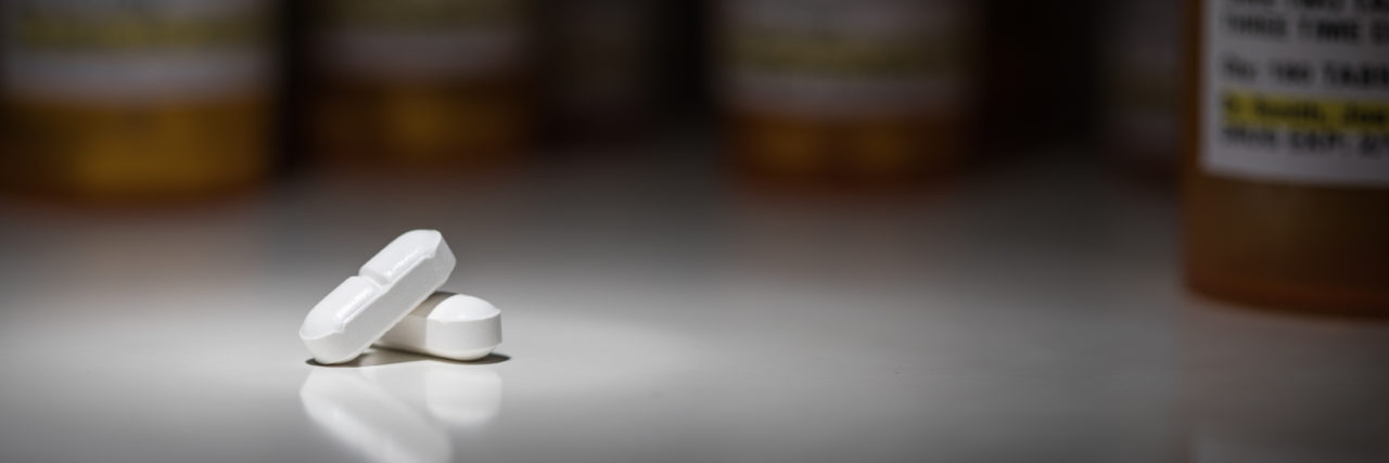 Pills with prescription bottles in the background.