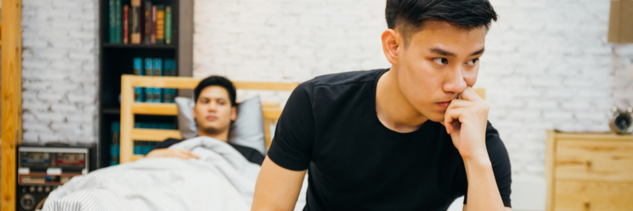 We’ve Talked About It Over and Over Again: Emotional Exhaustion couple having argument with each other in bedroom. Thoughtful gay man having stress while another is sleeping