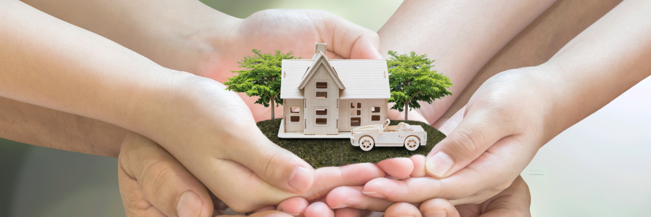 Home Safety Tips for People With Epilepsy Hands holding miniature house.