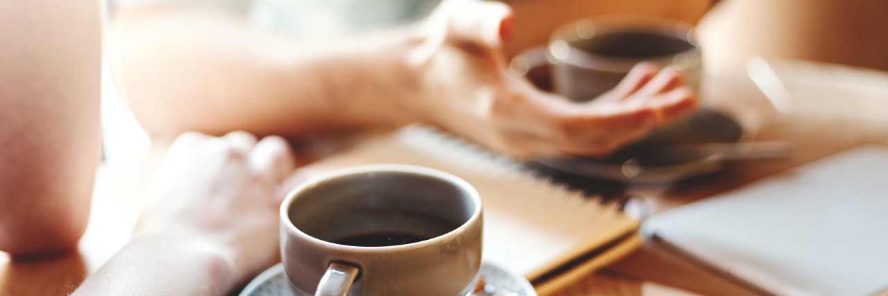Sharing About Your Rare Condition With Friends: What to Know Friends talking at cafe table, focus on coffee cups and hands