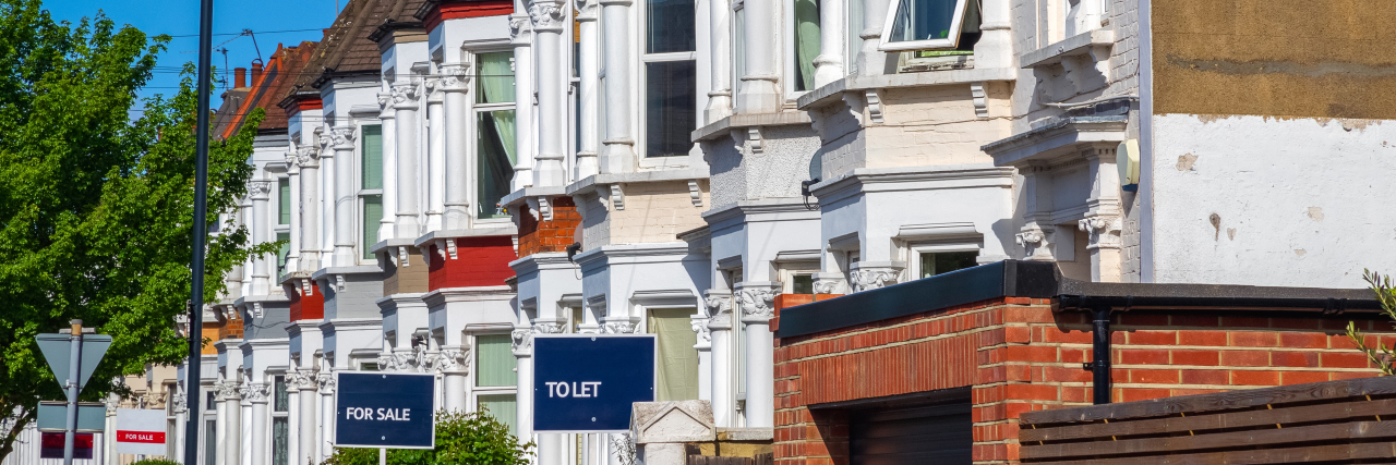Disability Discrimination in the U.K. Housing Rental Market A row of typical British terraced houses around Kensal Rise in London with estate agent boards.