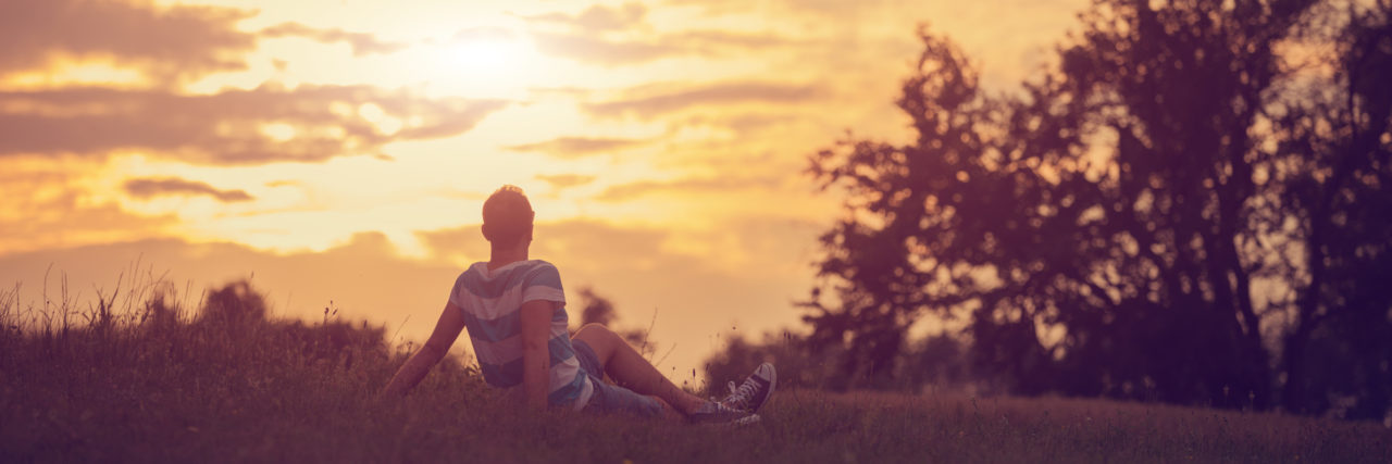 Overcoming Society's Low Expectations in My Life With a Disability Man enjoying nature at sunset.