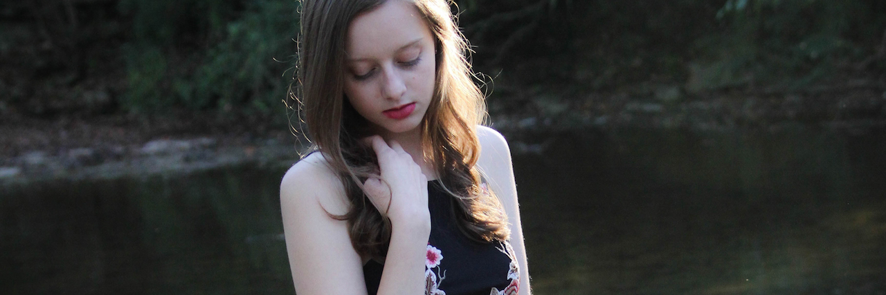 You Can't See My Daughter's OCD, but It's Real The author's daughter as a teenager, wearing a dress and posing in front of a lake.