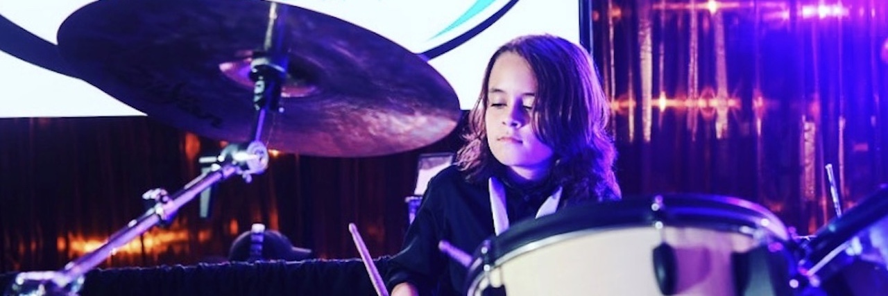Boy playing drums on stage
