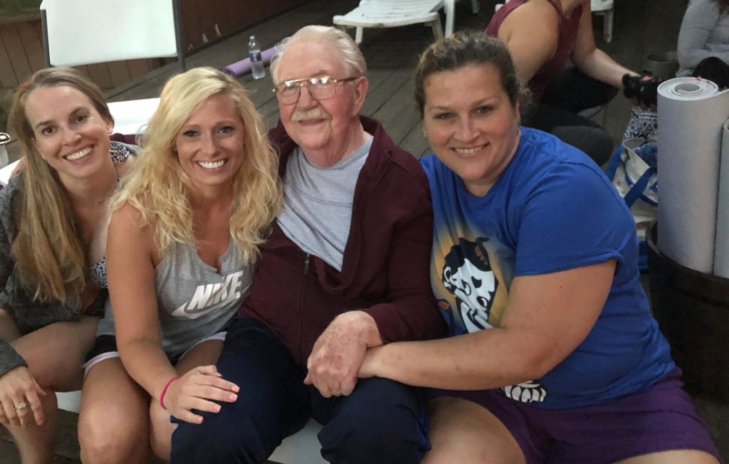 photo of contributor and two other women sitting beside an elderly man