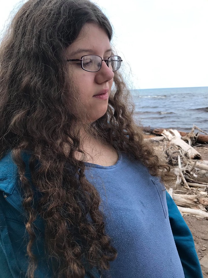 Naomi standing by the beach.