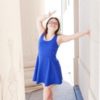 Young woman with Down syndrome posing for camera wearing bright blue dress