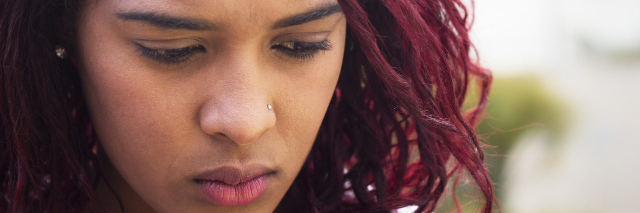 16 Cosas Que Haces Cuando Estás 'Entumecido' Emocionalmente Mujer Afroamericana con expresion triste.