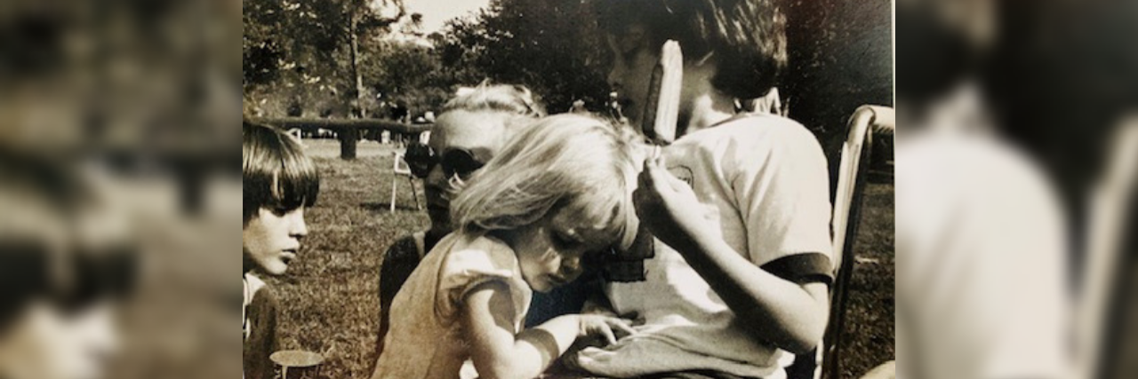 The author as a child hugging her brother, who sits in a wheelchair