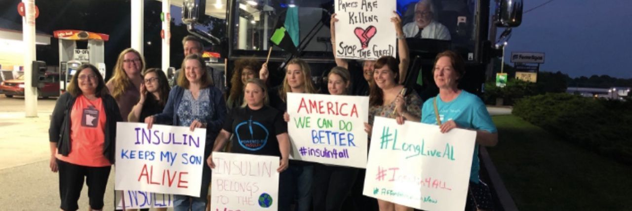 women with diabetes holding signs outside bus