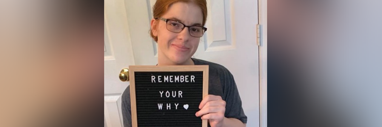 Why Getting a New Wheelchair Is Often Difficult Alyssa holding a signs that says "remember your why."