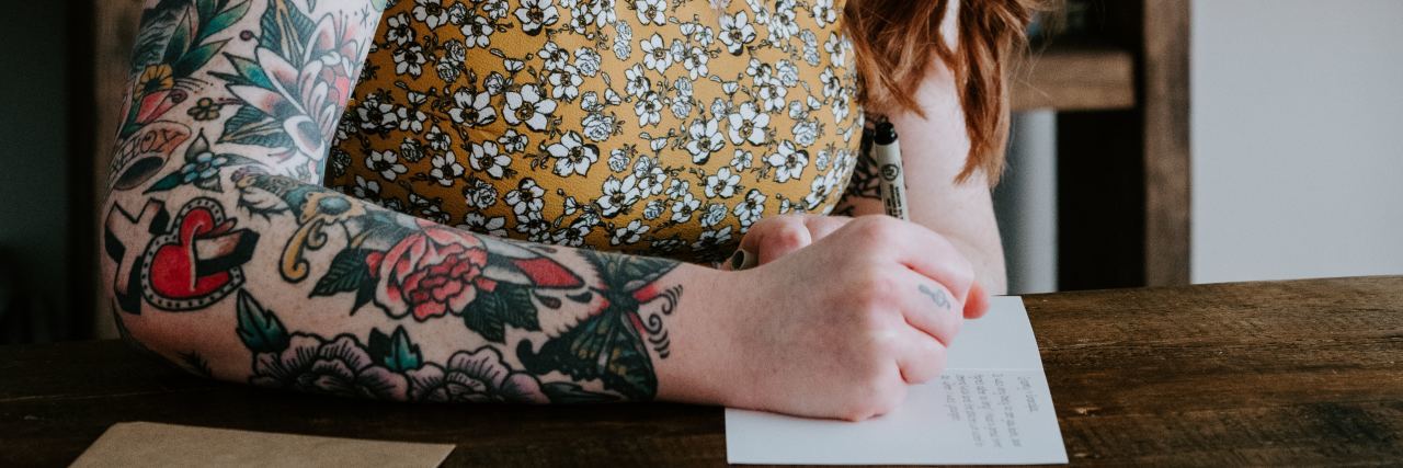 Write a Letter to Your Future Self Who Wants to Die by Suicide photo of redhead woman with tattoos writing a letter