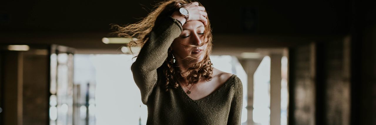 What Medical Staff Should Know About Life With Endometriosis photo of woman standing in dark building with hand in hair