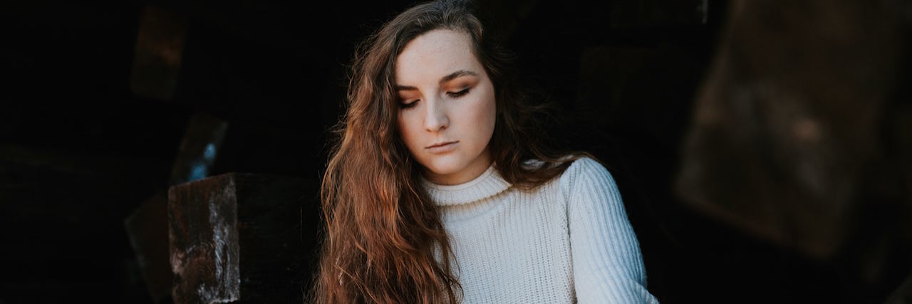 Signs You Might Miss When a Friend Dies by Suicide A woman with long hair looking down