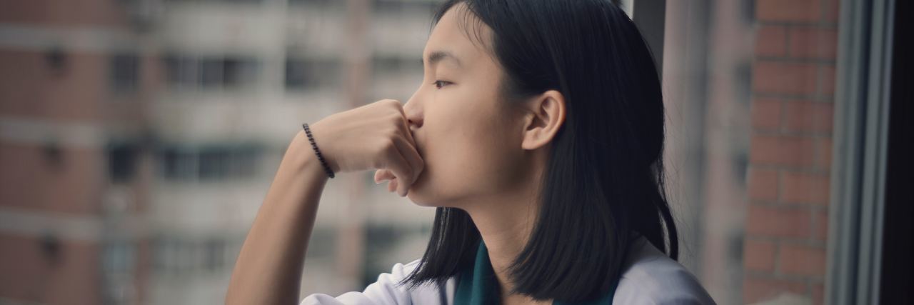 How Chronic Anorexia Changed the Way I Measure Success woman looking out window in city building