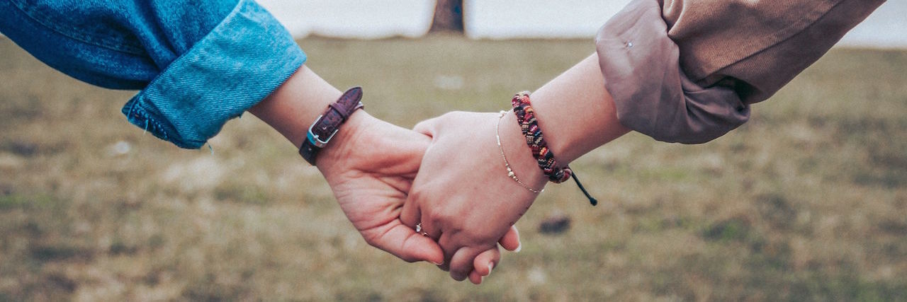 Feeling Like You're 'Too Much' for Your Friends Two people holding hands