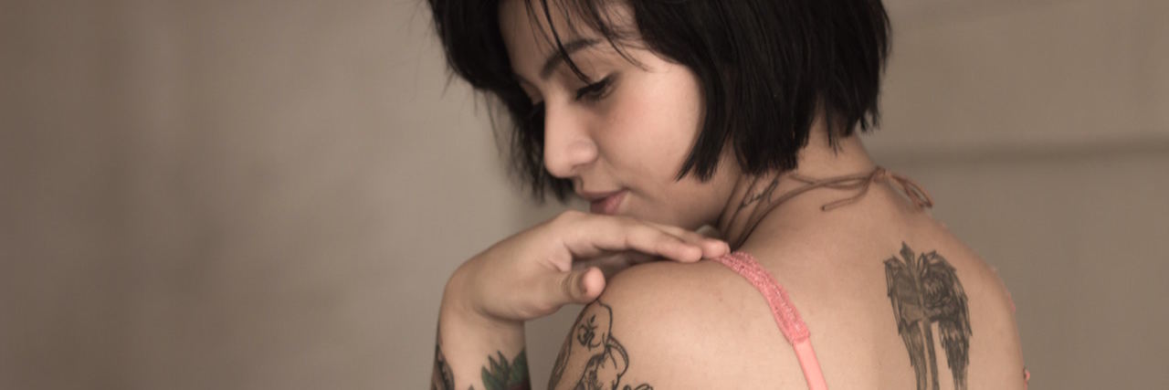 Borderline Personality Disorder Can Leave You With Trauma A woman with dark hair and tattoos