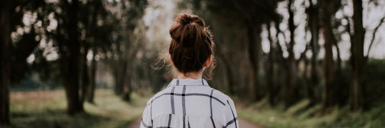 How 'Selective Isolation' Helps Me Cope With PTSD woman walking in the forest