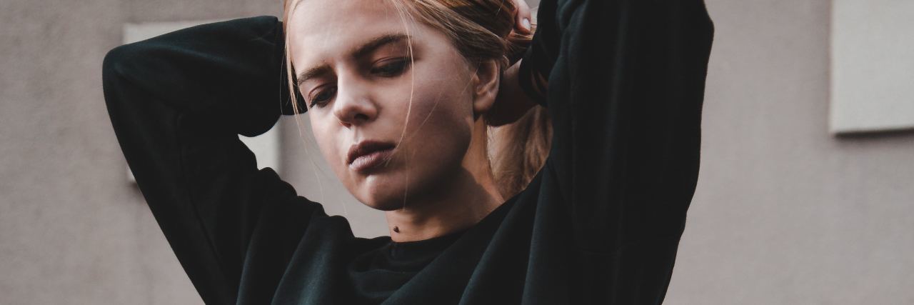 What to Know When Someone Says You Aren’t Ready for Therapy photo of young woman with arms raised behind her head with eyes closed