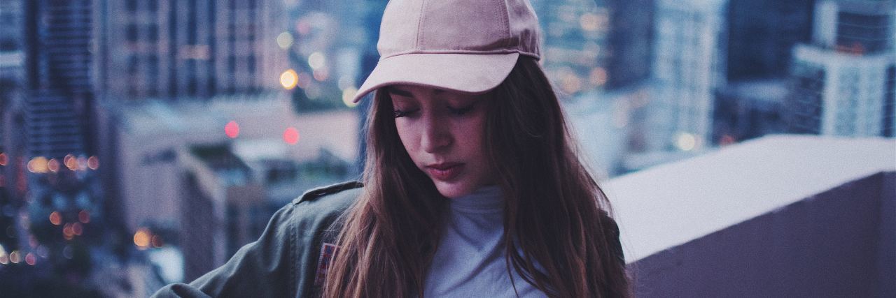 How to Get Through Anxiety in the Moment photo of woman standing on roof looking sad or anxious