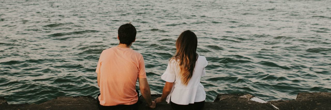man and woman looking at ocean