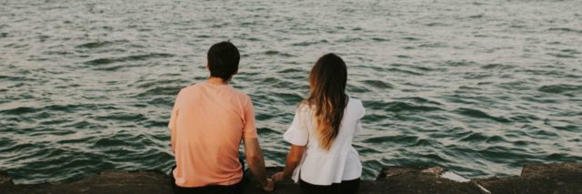 man and woman looking at ocean
