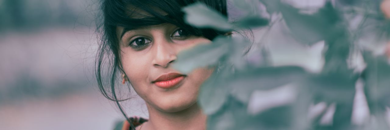 How I Can Work With Depression and Anxiety photo of young woman smiling and standing behind plants